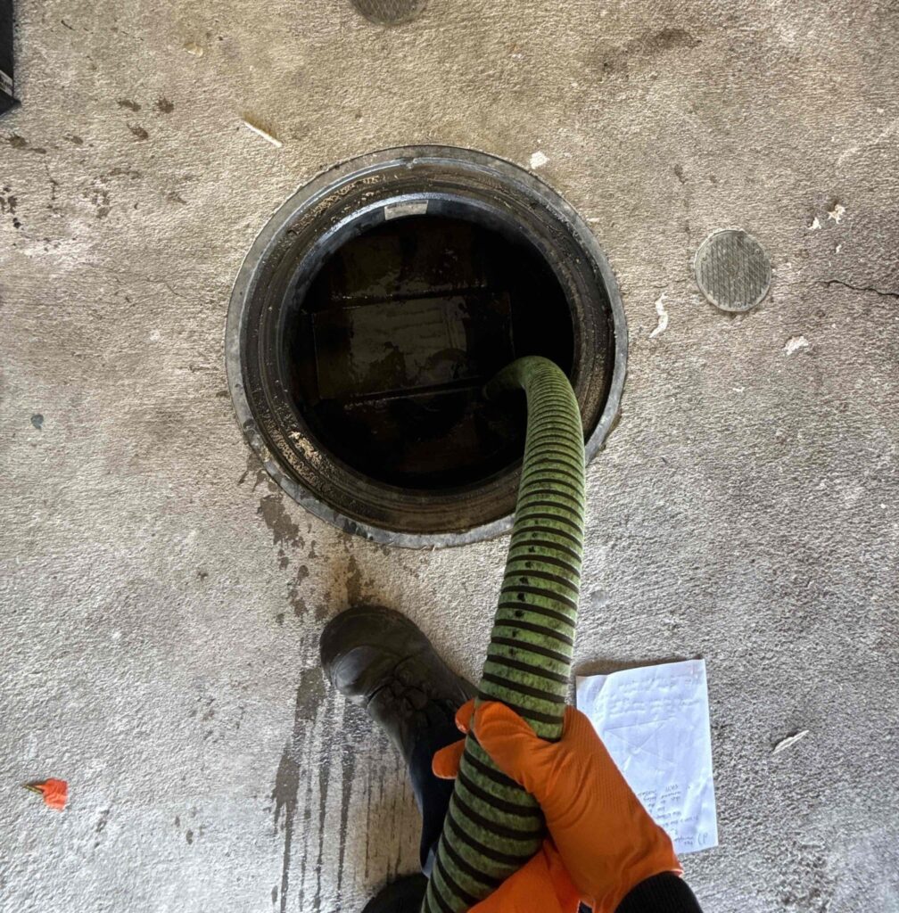 a magnolia worker pumping a grease trap
